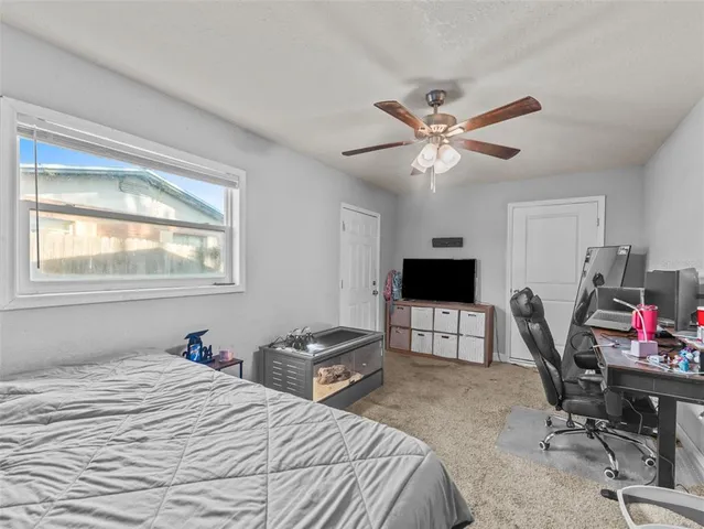 a bedroom with bed tv and a window