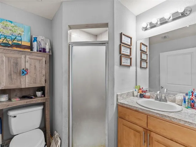 a bathroom with a granite countertop sink toilet and a mirror