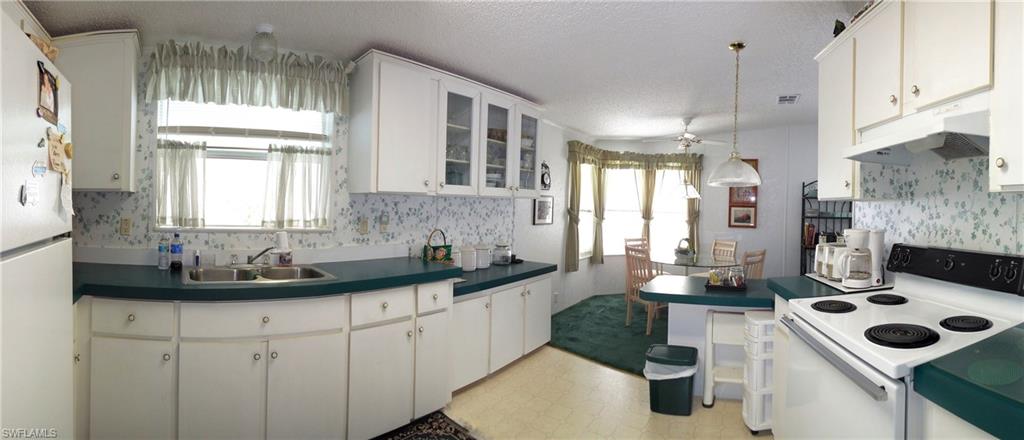 913 Manatee Road Naples, FL 34114 - Photo 4 of 13 a kitchen with a sink stove and cabinets