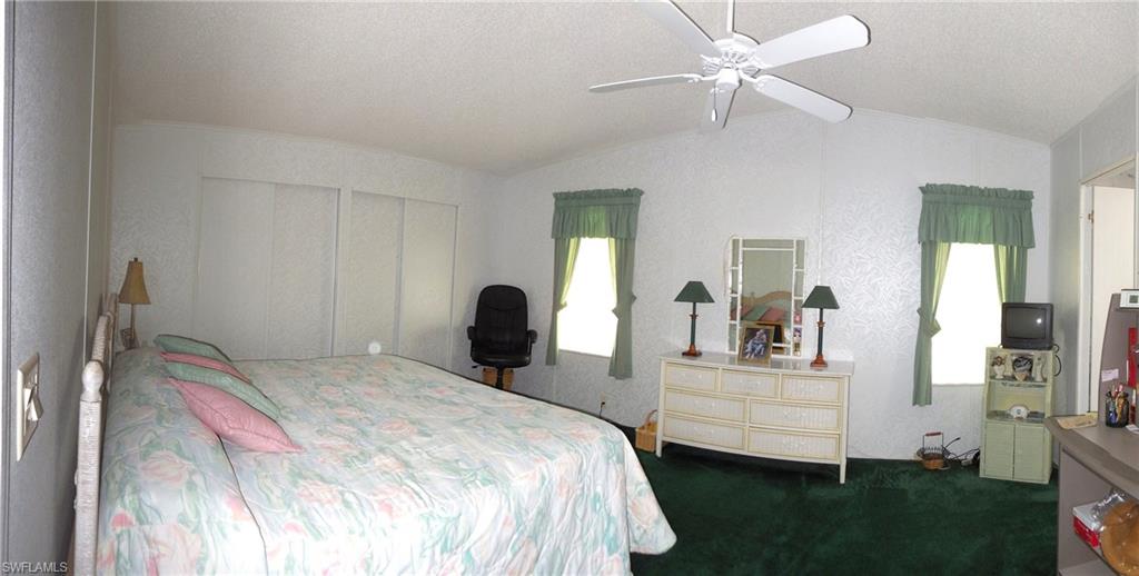 913 Manatee Road Naples, FL 34114 - Photo 7 of 13 a bedroom with a bed and a chandelier