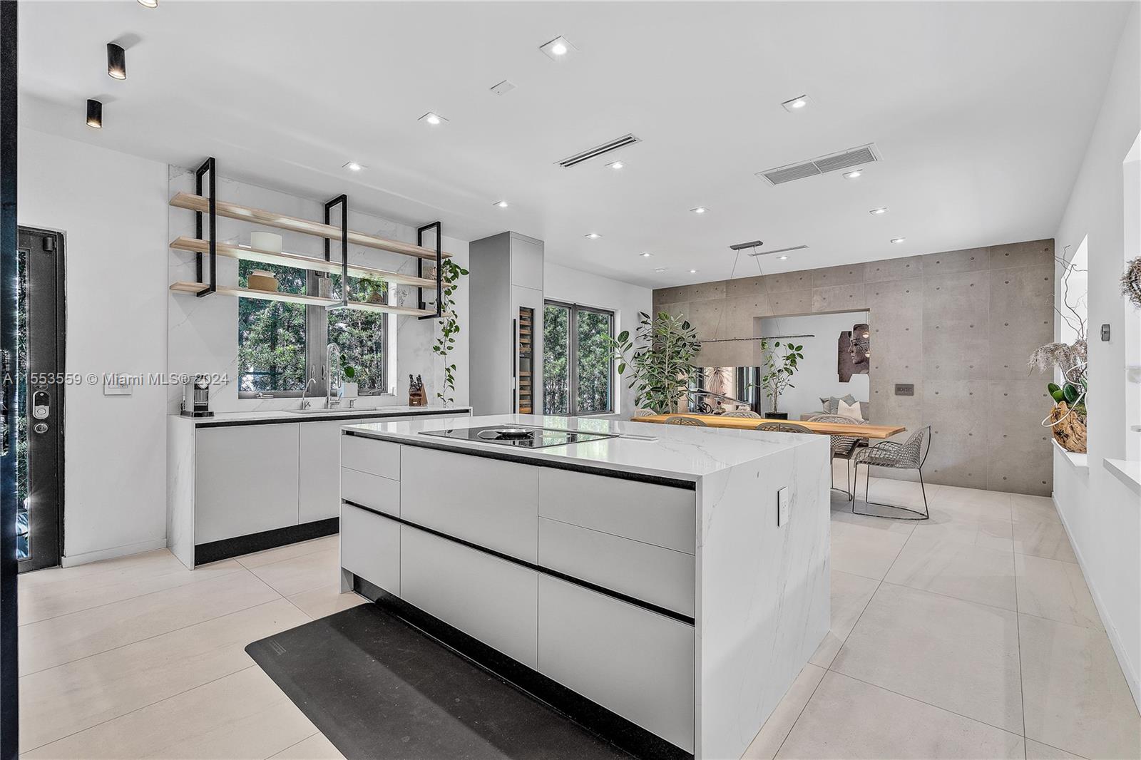 a large white kitchen with a large window and counter space