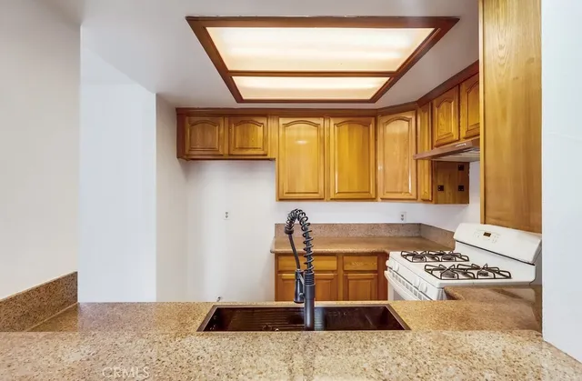 a kitchen with a stove top oven cabinets and a window
