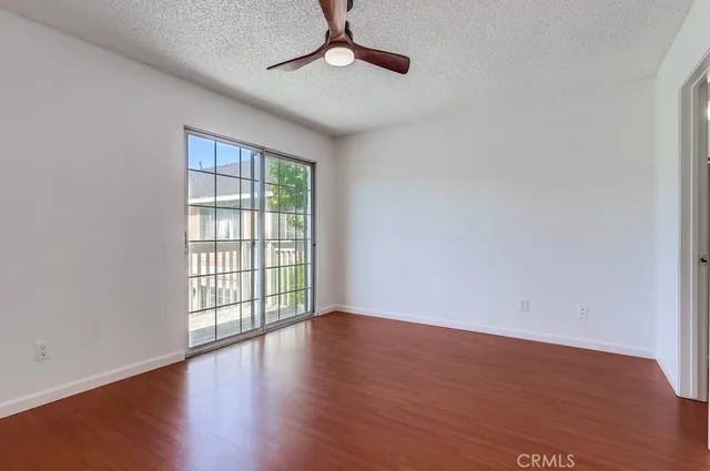 a view of a room with wooden floor and a ceiling fan