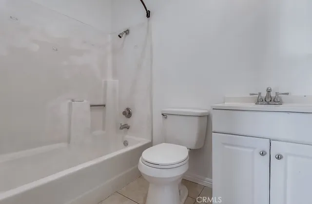 a white toilet sitting next to a bath tub
