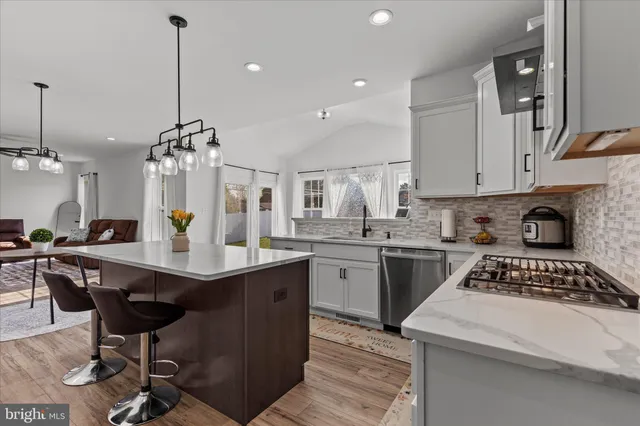 a kitchen with a sink a stove cabinets and wooden floor