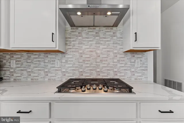 a stove top oven sitting inside of a kitchen
