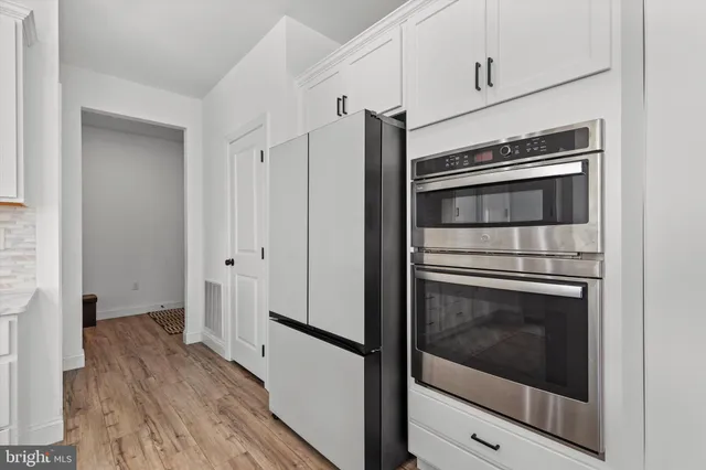 a kitchen with cabinets and stainless steel appliances