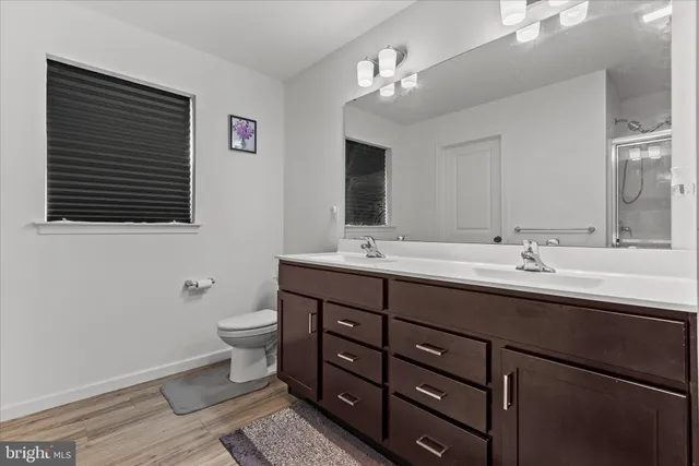 a bathroom with a double vanity sink a toilet and a mirror
