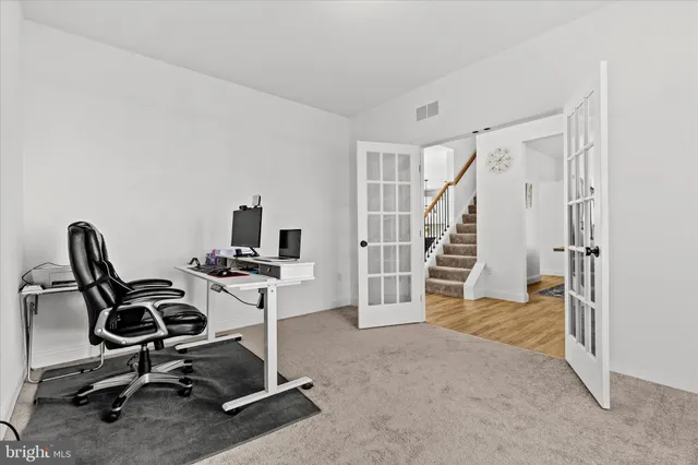 a view of a workspace with furniture and a window