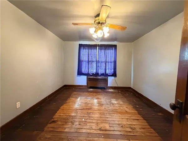 a view of a room with window a ceiling fan and wooden floor