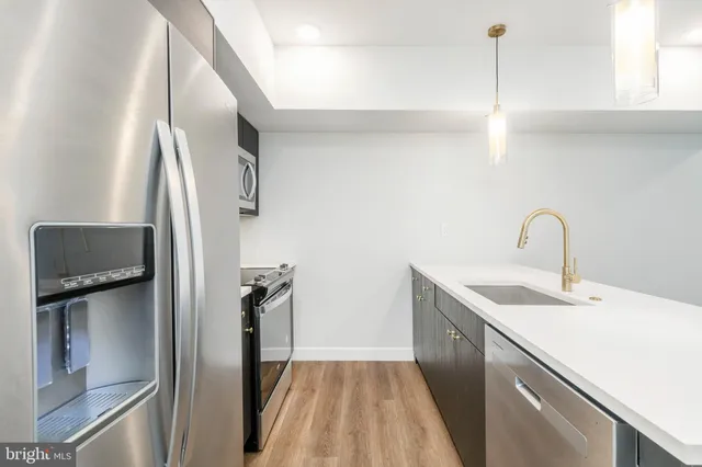 a kitchen with a sink and stainless steel appliances