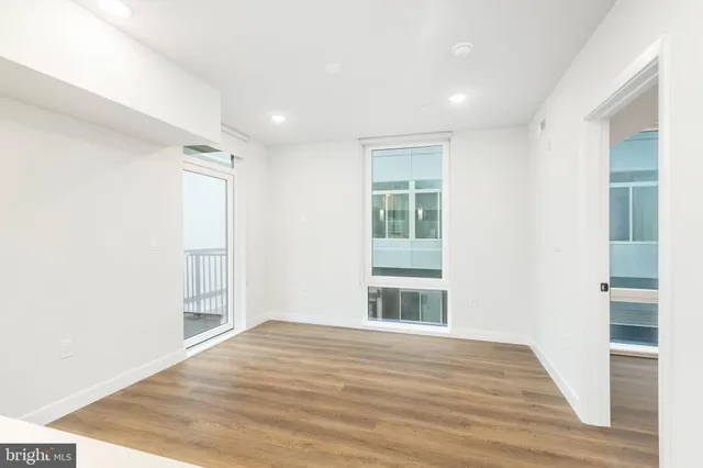 a view of empty room with wooden floor
