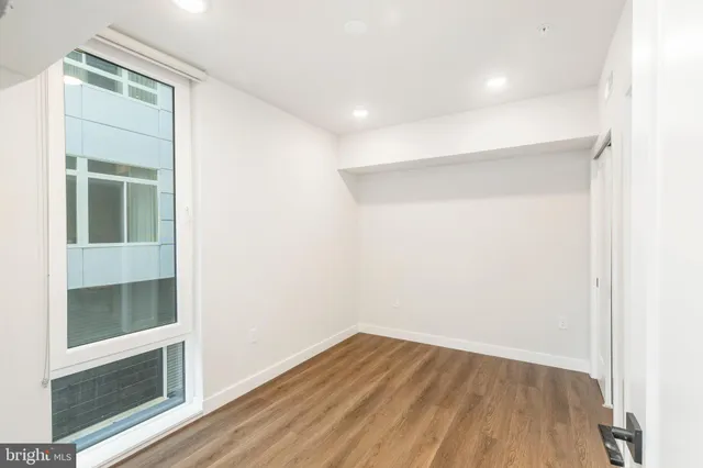 a view of empty room with wooden floor