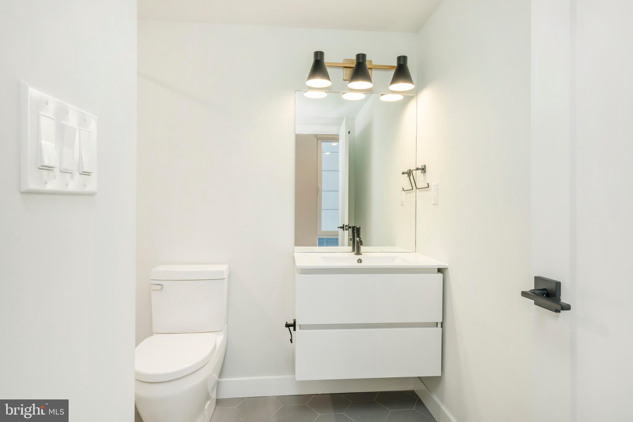 1102 Germantown Avenue, Unit 302 Philadelphia, PA 19123 - Photo 19 of 30 a bathroom with a toilet a sink and mirror