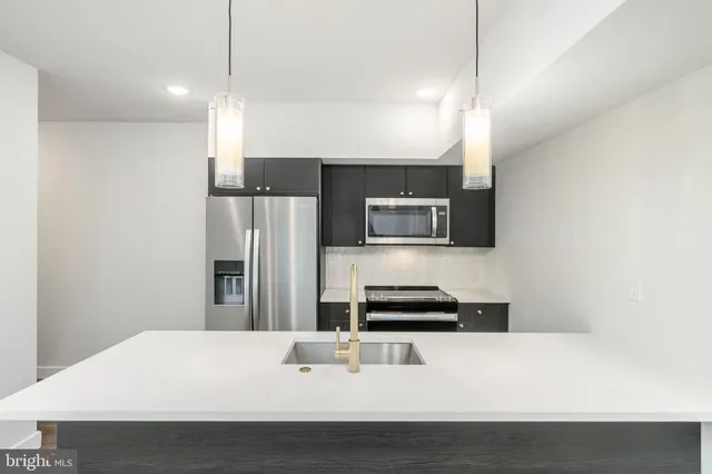 a kitchen with a sink a microwave and cabinets