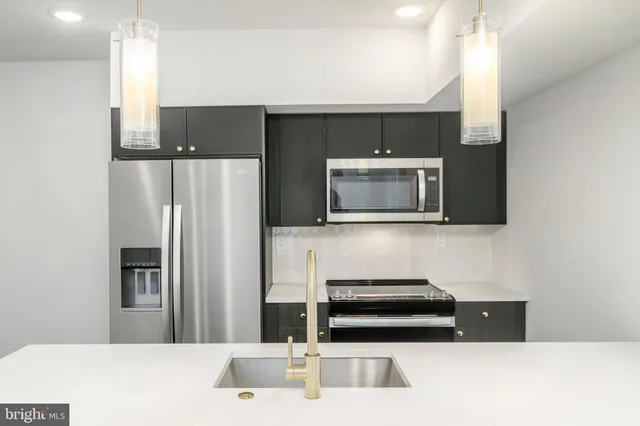 a kitchen with stainless steel appliances a refrigerator and a microwave