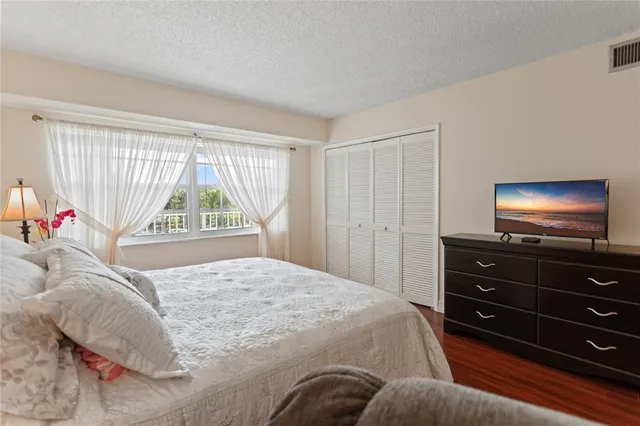 a bedroom with a bed and a flat screen tv