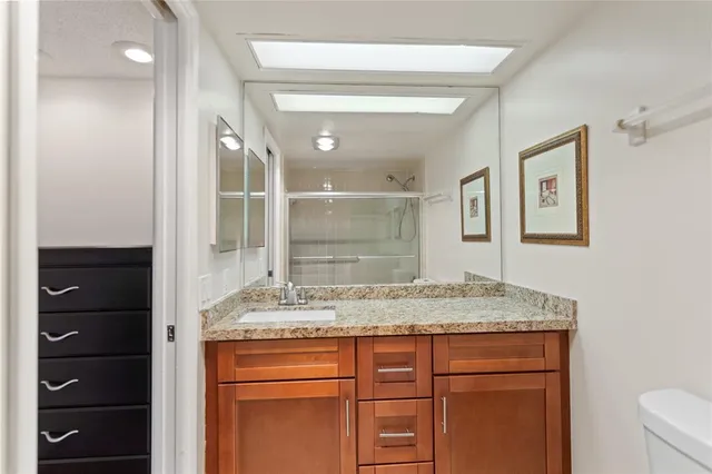 a bathroom with a granite countertop sink and a mirror