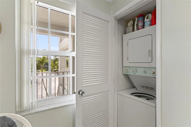 a kitchen with white cabinets and a window