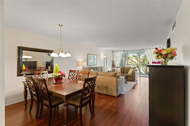 a view of a dining room with furniture wooden floor and chandelier