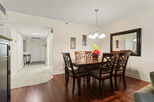 a dining room filled chandelier and wooden floor