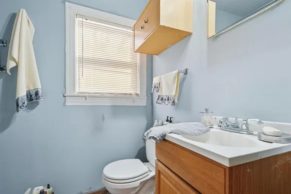 a bathroom with a sink vanity mirror and toilet