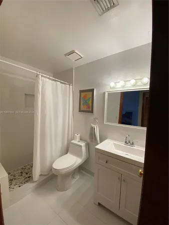 a spacious bathroom with a double vanity sink toilet mirror and shower