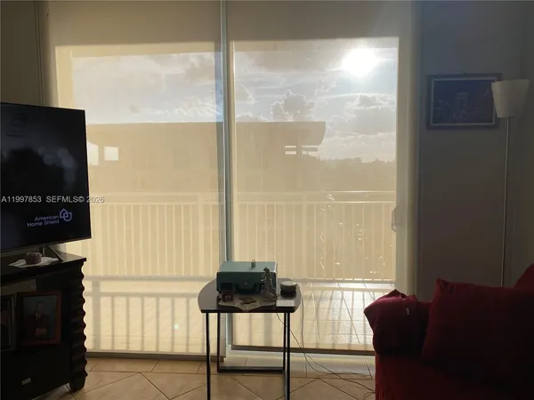 a view of a living room with a large window and furniture