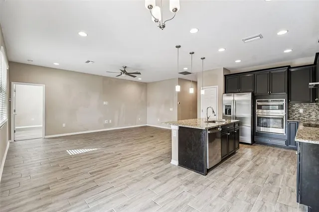 an empty room with wooden floor and ceiling fan