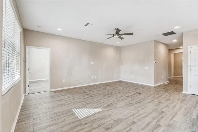 a view of empty room with wooden floor