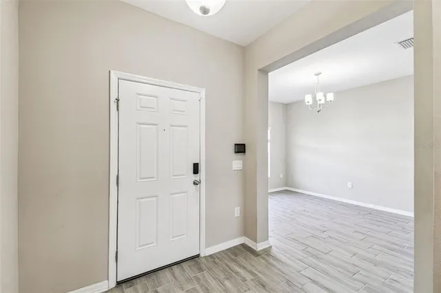 a view of a hallway with wooden floor and entryway