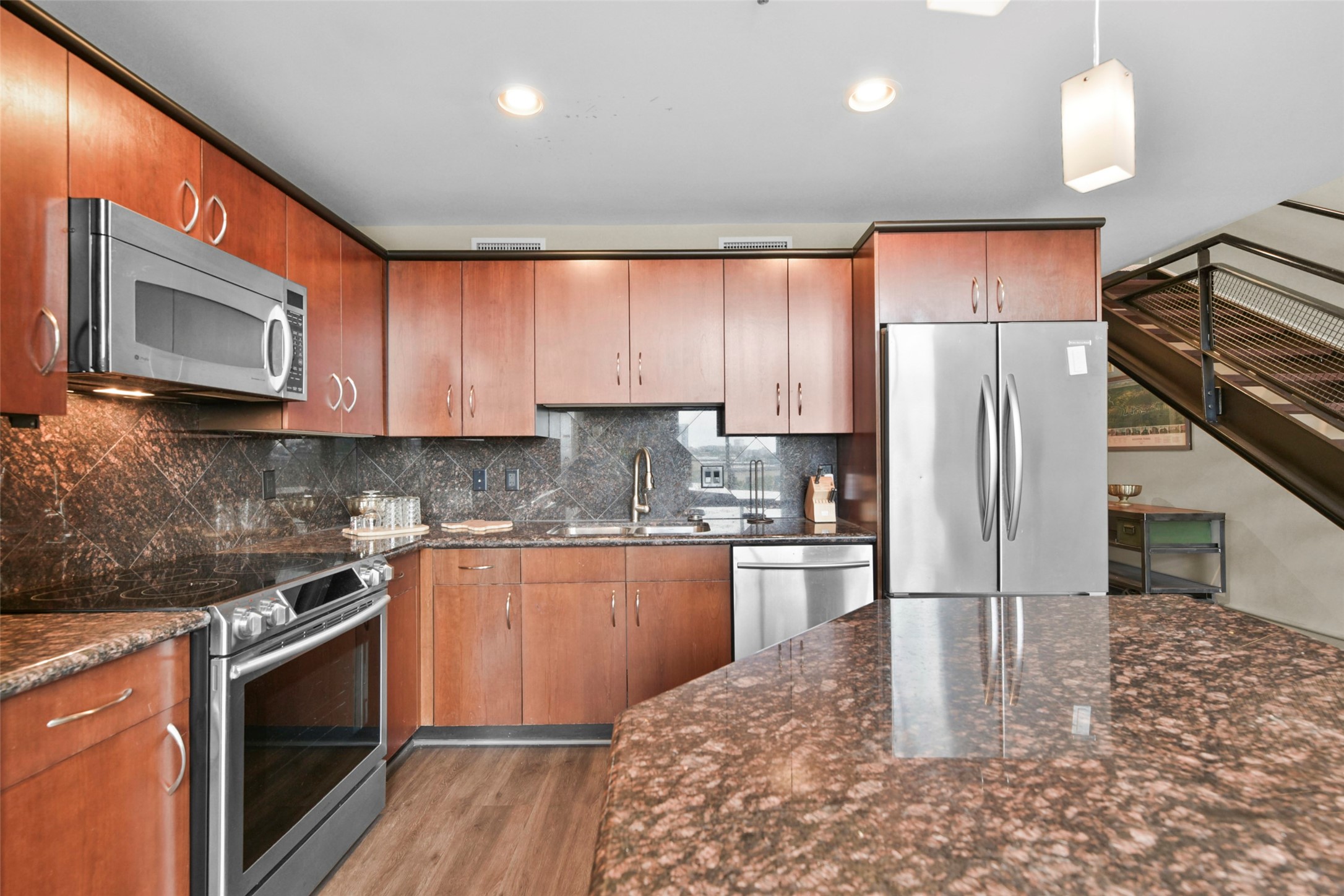 3311 Yupon Street, Unit 611 Houston, TX 77006 - Photo 7 of 17 a kitchen with stainless steel appliances granite countertop a refrigerator a stove microwave and sink