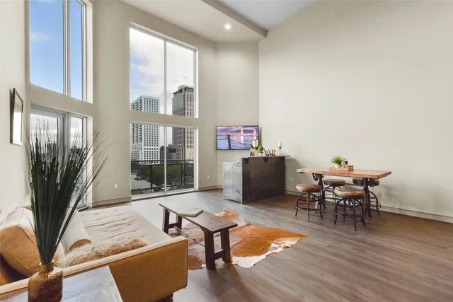a living room with furniture a table and a floor to ceiling window