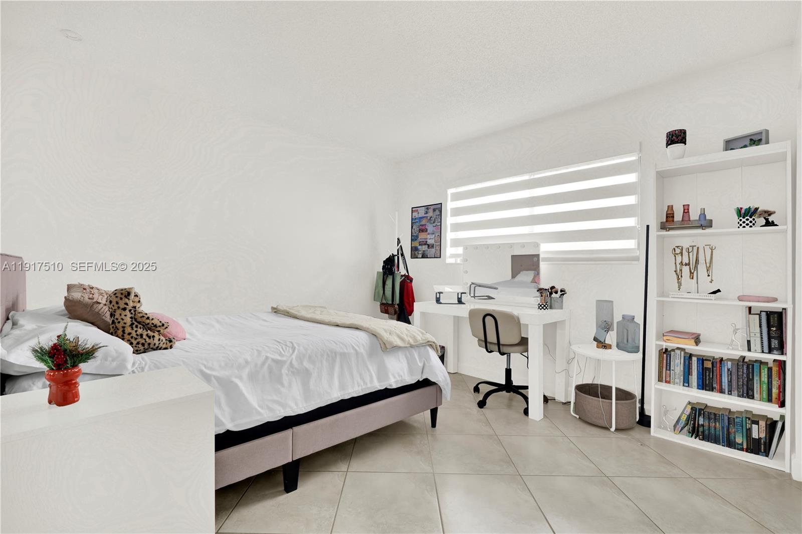 12221 Southwest 93rd Street Miami, FL 33186 - Photo 27 of 42 a bedroom with a bed and a book shelf