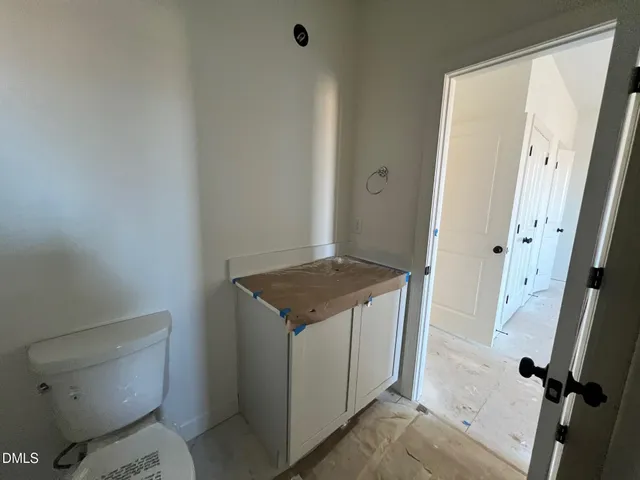 an empty room with wooden floor chandelier fan and windows