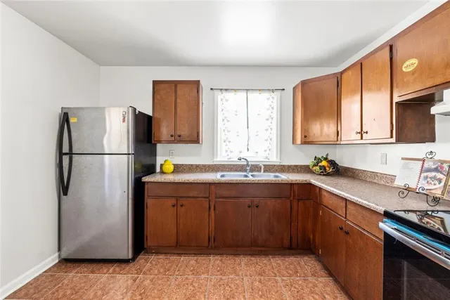 a kitchen with stainless steel appliances granite countertop a refrigerator a sink dishwasher a stove with wooden cabinets