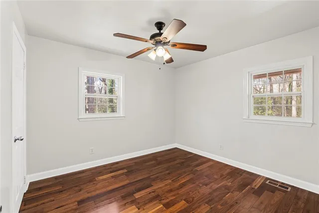 a view of empty room with wooden floor