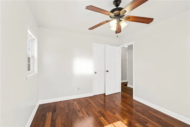 a view of a room with wooden floor and a ceiling fan