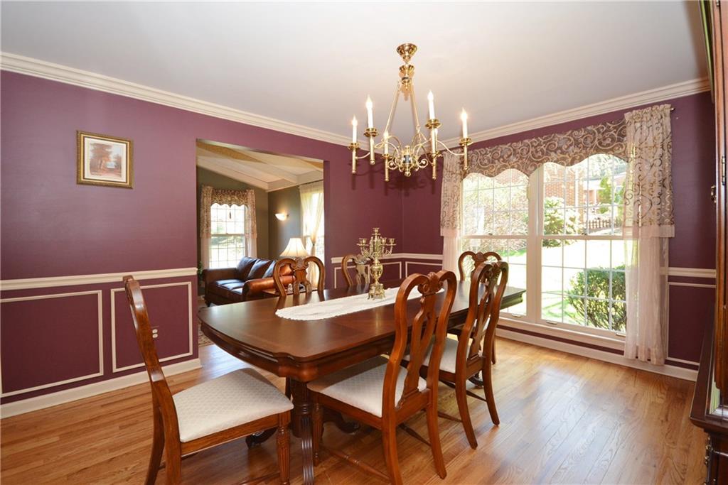 Large dining room with large windows and nice trim work including crown moulding, chair rail & panel mould.