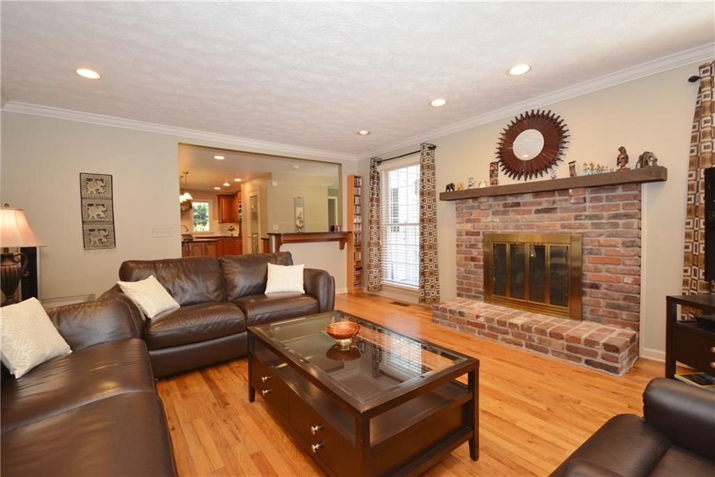 207 Springhouse Lane Pittsburgh, PA 15238 - Photo 8 of 25 Family room looking into the kitchen. Large windows provide lots of light, gleaming hardwood floors, recessed lights and cozy fireplace with brick hearth and surround.