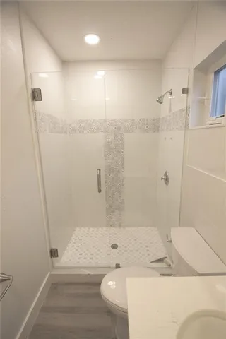 a bathroom with a granite countertop sink a toilet and shower