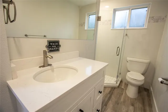 a bathroom with a sink a toilet and shower