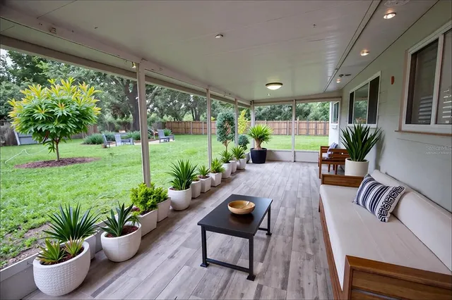 a view of a porch with furniture and a backyard