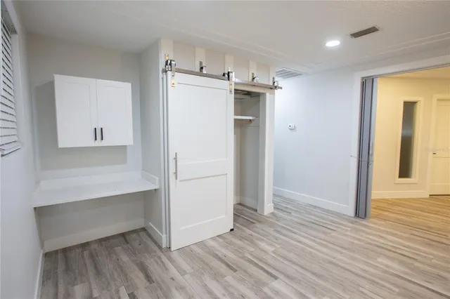 a view of empty room with wooden floor