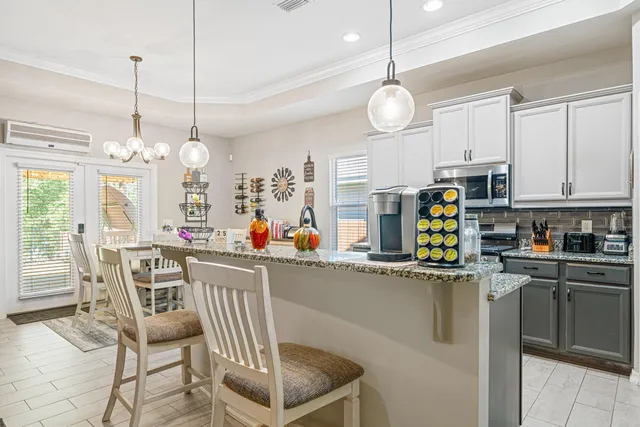 a kitchen with stainless steel appliances a table chairs and white cabinets
