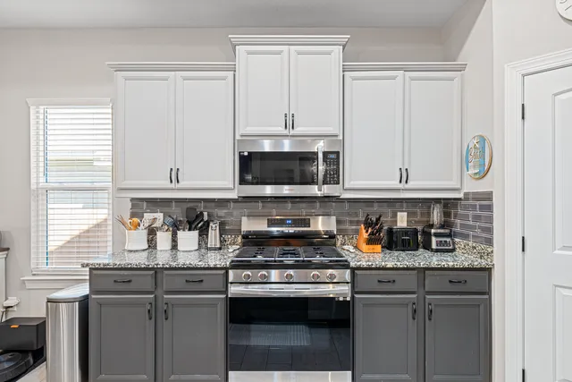 a kitchen with stainless steel appliances granite countertop a stove and a microwave