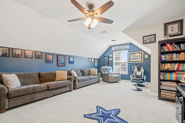 a living room with furniture and a book shelf