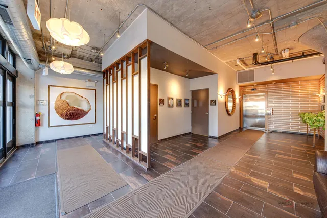 a view of a hallway with wooden floor and a chandelier