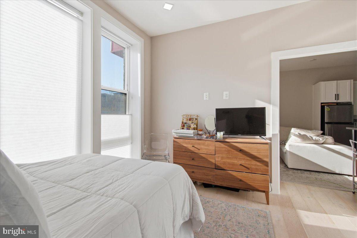 1028 Bladensburg Road Northeast, Unit 18 Washington, DC 20002 - Photo 12 of 22 a bedroom with bed a flat tv and a couch