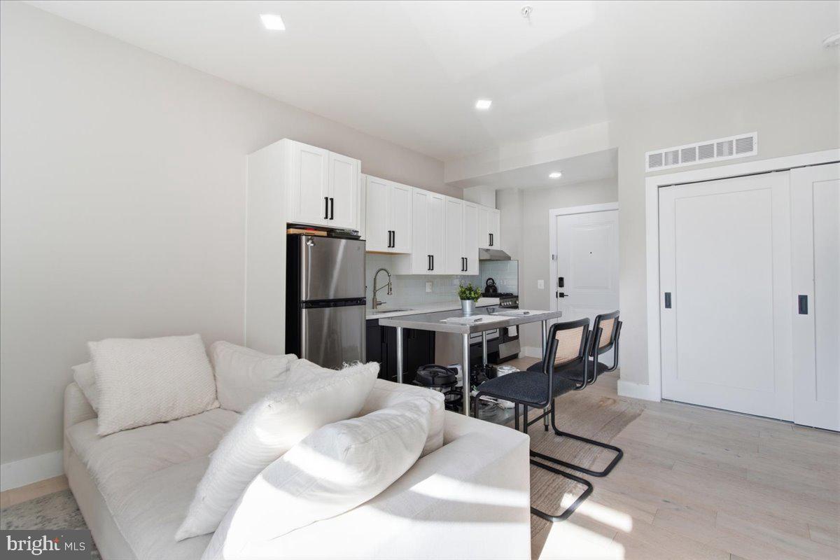 1028 Bladensburg Road Northeast, Unit 18 Washington, DC 20002 - Photo 4 of 22 a living room with furniture a fireplace and kitchen view